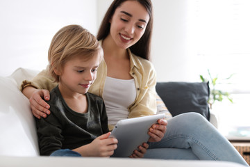 Mother and son reading E-book together at home