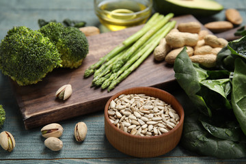 Different products rich in vitamin E on blue wooden table, closeup