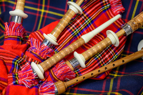 Scottish folk antique musical instrument bagpipes and colorful tartan fabric