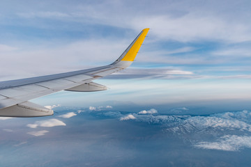 Fototapeta premium ala de avión airbus a320 sobre sierra nevada, españa. se ve el cielo azul con nubes y las montañas