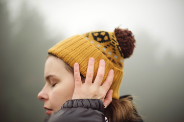 woman standing by forest in foggy weather