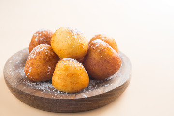 French doughnuts Beignet covered with sugar powder on a brown background