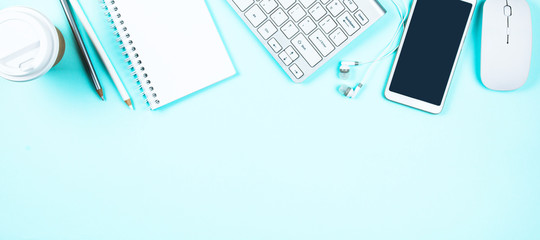 White keyboard, mouse and Notepad on light turquoise background. Flat lay and top view, copy space...
