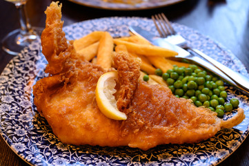 Traditional British food fish and chips served with green peas