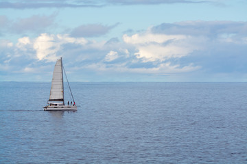 Fototapeta premium Seascape with one sail boat, cloudy sky and waves of Atlantic ocean