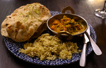 Mangalorean style roasted cauliflower and spinach curry with basmati rice and garlic naan bread, tasty vegetarian food