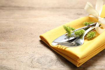 Cutlery set on wooden table, closeup view with space for text. Easter celebration