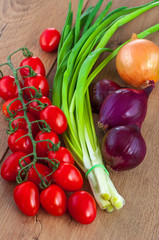  Red cherry tomatoes on a branch and green onions