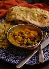 Mangalorean style roasted cauliflower and spinach curry with basmati rice and garlic naan bread, tasty vegetarian food
