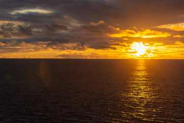 Obraz premium Amazing sunset with colorful clouds and dark ocean water, nature background