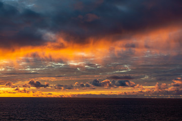 Amazing sunset with colorful clouds and dark ocean water, nature background