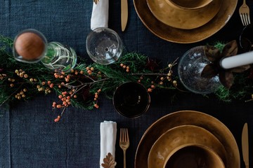 greenery and berries on a decorated dinner table
