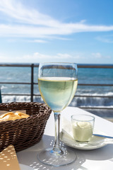 Summer holiday on sea, drinking white wine on outdoor terrace with sea view in sunny day