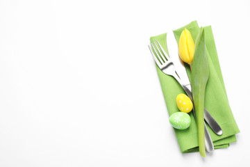 Top view of cutlery set with floral decor for Easter celebration on white background