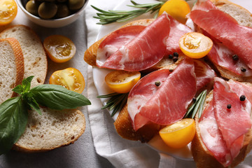 The concept of Italian cuisine. Coppa - Italian dried sausage made from pork neck. Meat snacks. Baguette, olives, checopy space