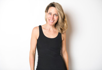 beautiful woman wearing black tank top over white studio wall.