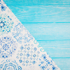 Turquoise wooden background with a beautiful tablecloth, copy space