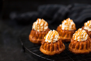 Homemade carrot cupcakes with caramel sauce and cream cheese frosting
