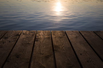 Wooden boardwalk with the reflection of the sun in the water