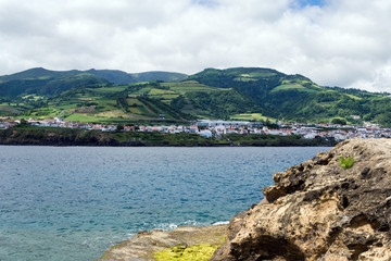 Fototapeta na wymiar View of the beautiful village of Vila Franca do Campo on the island of San Miguel from the volcanic uninhabited island of Vila Franca, Azores, Portugal. Travel to the Azores.