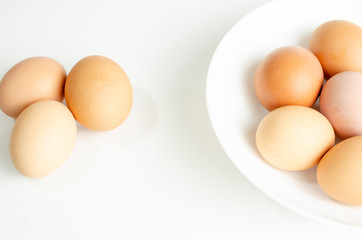 fresh brown eggs on a white plate in a deep plate