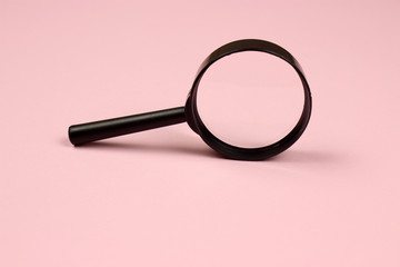 Magnifying glass on a pink background. Top view. Copyspace for your text