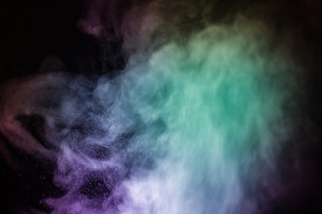 Colorful smoke flowing in a dark background. Abstract backdrop with fume and colorful light effect. Mystic dream. Colorful dust explode. Paint Holi. Halftone smoke effect. Vibrant abstract background.