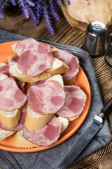 Sandwich made of wheat bread, butter and slices of dry-cured sausage.