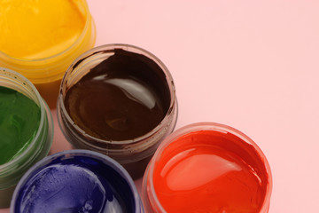 Gouache cans on a pink background with space for text