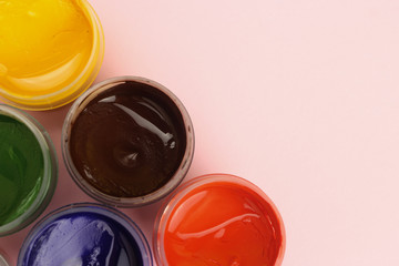 Gouache cans on a pink background with space for text