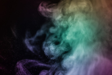 Colorful smoke flowing in a dark background. Abstract backdrop with fume and colorful light effect. Mystic dream. Colorful dust explode. Paint Holi. Halftone smoke effect. Vibrant abstract background.