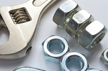 screw-nut of different sizes, bolts and adjustable spanner. White background. Concept.