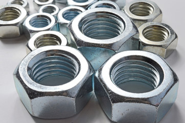 New chrome screw-nut of different sizes on a white background. Concept.