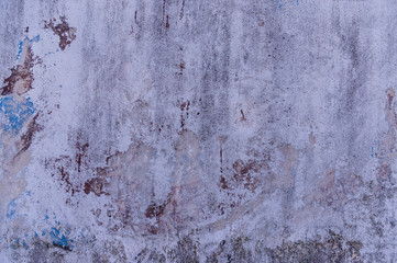 Verputzte Wand mit mehreren Anstrichen übermalt in verschiedenen Farben die unterschiedlich stark abgeblättert sind durch Verwitterung und Abrieb dadurch entstanden unterschiedliche abstrakte Muster