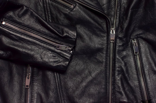 Close up details Black women's leather jacket top view. Fashionable modern trendy women's clothing. Vintage biker jacket. Black genuine leather texture