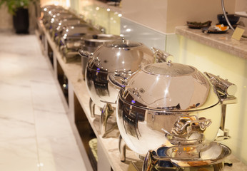 Aluminium warm chafing dishes for heating food in hotel restaurant food catering service on buffet banquet for wedding ceremonies, seminars, meetings, conferences, parties and events. Utensil concept.