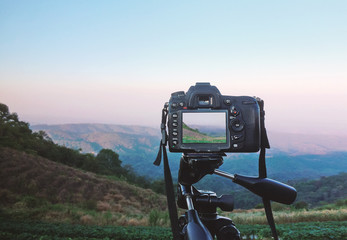 DSLR camera on tripod in the evening of mountain, Thailand