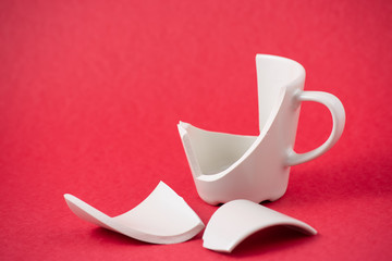 Broken Plate and dish or broken water glass on the on the red background The concept of accidents in the kitchen is dangerous for the body and young children inside the house.
