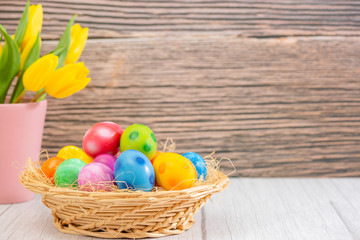 Fototapeta na wymiar Beautiful group Easter eggs in the spring of easter day, red eggs, blue, purple and yellow in Wooden basket on the table background wood.
