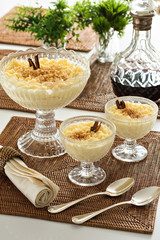 Rice pudding, a delicious dessert made from rice mixed with water or milk and other ingredients such as cinnamon. Served on a glass dessert bowl.