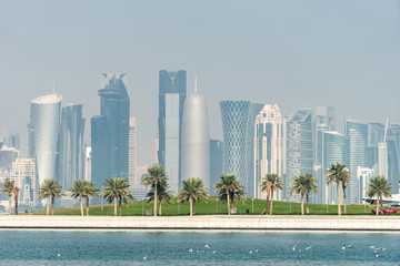 Fototapeta na wymiar Panoramic view of modern skyline of Doha with Palms foreground. Concept of healthy environment