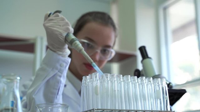 Female scientists use pipette dropper samples to test tubes.To conduct scientific experiments