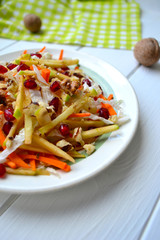 Healthy salad with cabbage, apples, carrots, nuts and pomegranate seeds.