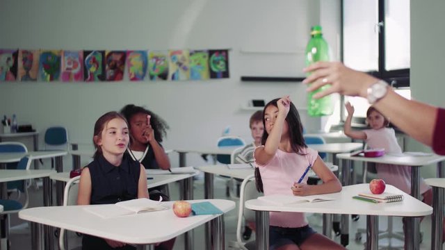 A teacher with small school kids in classroom learning about waste separation.