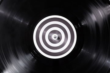 Vinyl record close-up dark background. Falling beam light piece of vinyl. Turntable record player. Sound technology DJ to mix & play music. Black vinyl record. Popular Disco Trends 60s, 70s, 80s, 90s