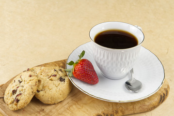 Hot coffee cup and breakfast baked on wooden board. Cup of tasty coffee with tasty cookies, on beige background. americano coffee and cookies with white berries. White Coffee Cup.