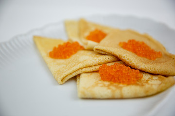 caviar with pancakes on a white plate