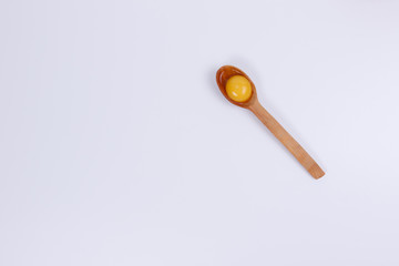 Egg yolk in a wooden spoon.