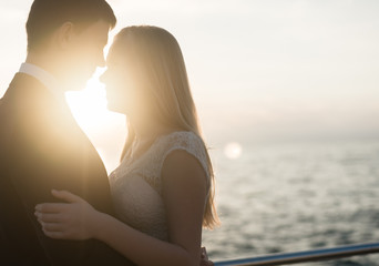 portrait of the bride and groom,newlyweds on the background of the sea,happy wedding couple on sea beach,newlyweds are hugging on the wedding day after the ceremony,wedding dresses on the bride