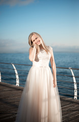 happy bride in a wedding dress,wedding outfit bride,young duffel is spinning in a wedding dress on a background of the sea,morning wedding photo shoot of the bride,bride portrait